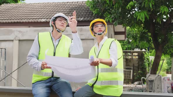 Asian colleague workers people wearing protective safety helmet and glasses onsite of architecture.