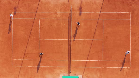 Aerial View. Players Are Playing Tennis on Orange Court