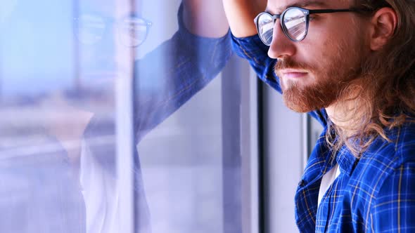 Male executive looking through window in office 4k