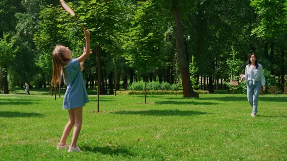 Cheerful Girl Playing Badminton with Mother in Park