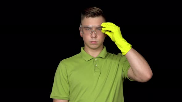 A Young Cleaner Puts on Glasses and Holds a Toilet Brush in His Hand. Man Is Ready for Cleaning. Man