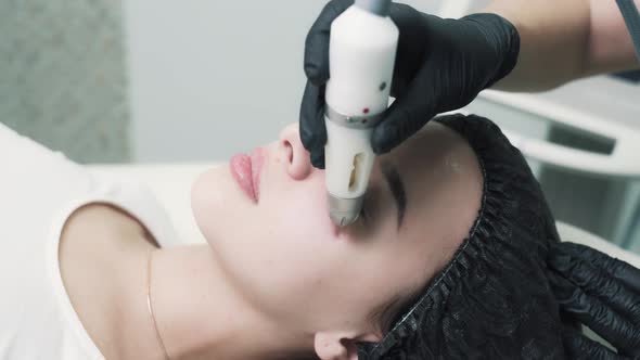 Young Beatiful Woman Take an Noninjection Mesotherapy on Pretty Face