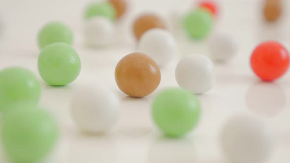 Bonbons in various colors on the white shiny and reflective background 4K 3840X2160 UHD video - Mixe