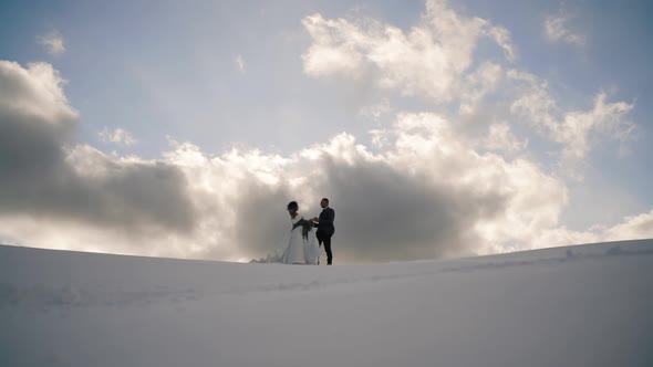 Newlyweds. Lovely Young Groom and Bride Stay Together on Top of the Mountain, Winter, Mountains