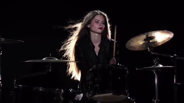 Drummer Girl Starts Playing Energetic Music, She Smiles. Black Background. Slow Motion