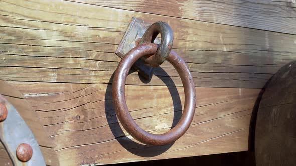 Rusty antique round knocker of ancient wooden weathered carriage falls