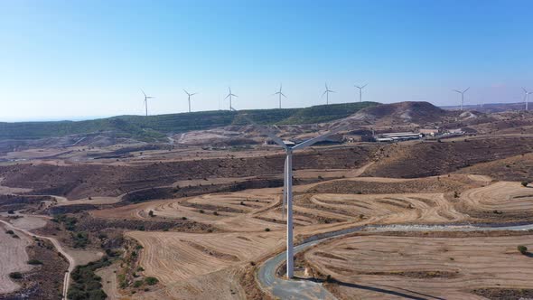 Boundless Fields with Shrubs and Road Against Wind Turbines