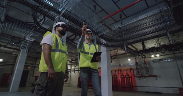 Male Builders in Goggles Examining Ceiling