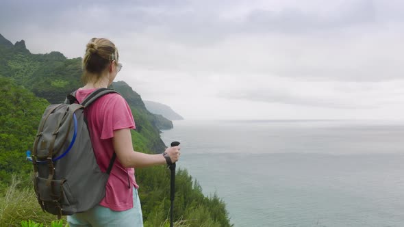 Slow Motion Smiling Woman Hiking By Trail with Cinematic NaPali Hawaii Landscape