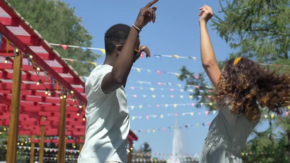 African American Man in Sunglasses and Brunette Woman Dance