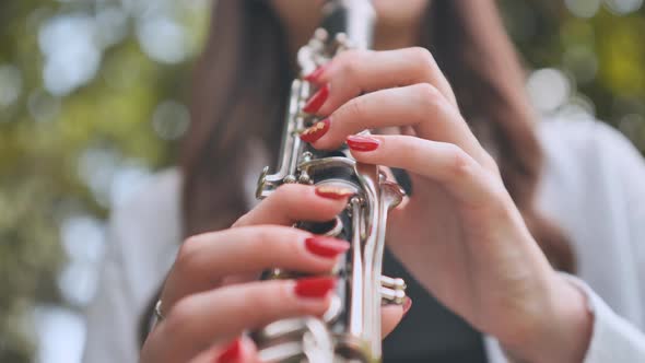 A Girl Plays the Clarinet in the Summer in the Park