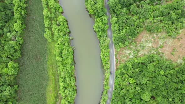 Flight with drone over a road around a river