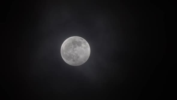 Full Moon Moving Between Clouds