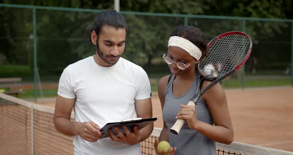 Black Woman Tennis Player and Coach on Tennis Court