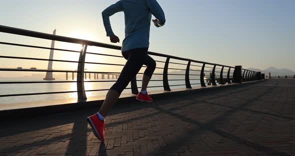 Fitness woman runner running on seaside bridge, slow motion