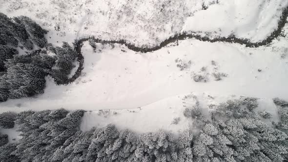 Birds Eye View Of Snowy Valley River And Power Lines
