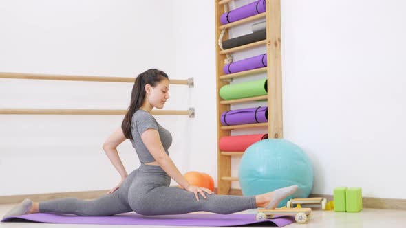 Young Woman is Doing Gymnastics in Gym