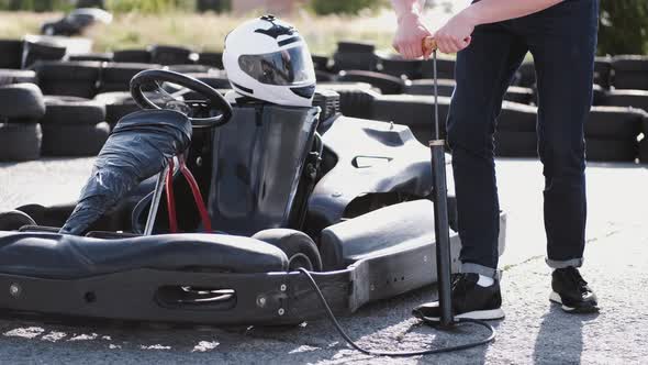 Attractive Man Checking Tire Pressure on His Gocart