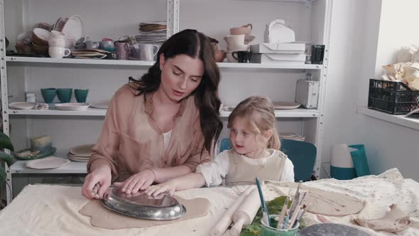 Portrait of Mother and Little Girl Shaping Clay Together