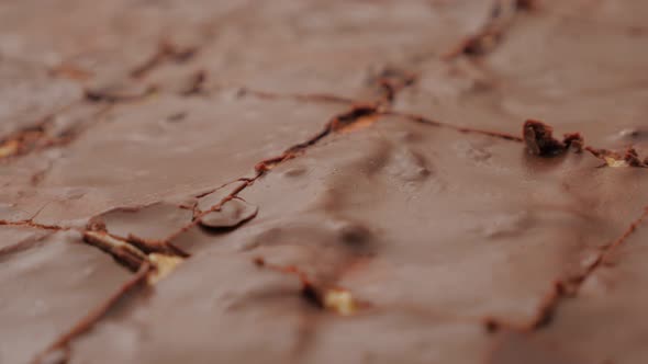 Cake glazed with chocolate and divided on small pieces slow panning 4K 3840X2160 UHD footage - Tasty