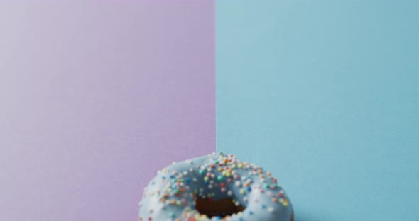 Video of donut with icing on purple and blue background