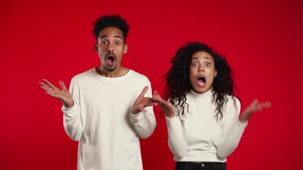 Amazed African American Man and Woman Shocked, Saying WOW. Young Couple