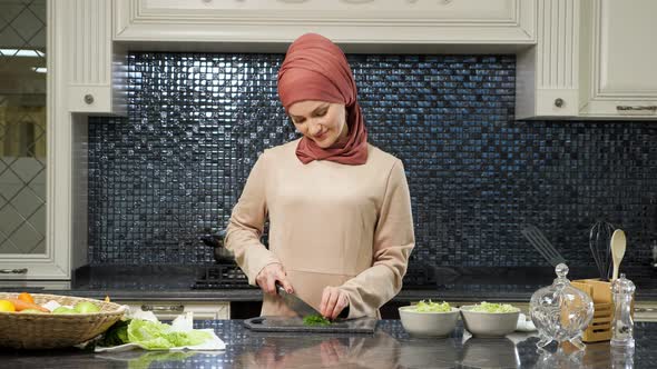 Oriental Woman Cooks Meal Cutting Fresh Greens Smiling