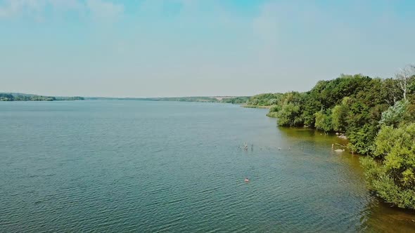 along the riverbank hd aerial view. Drone flight along the riverbank.