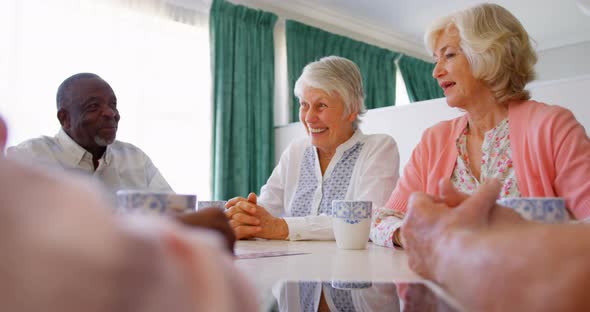 Group of Mixed-race senior friends interacting with each other on dining table 4k