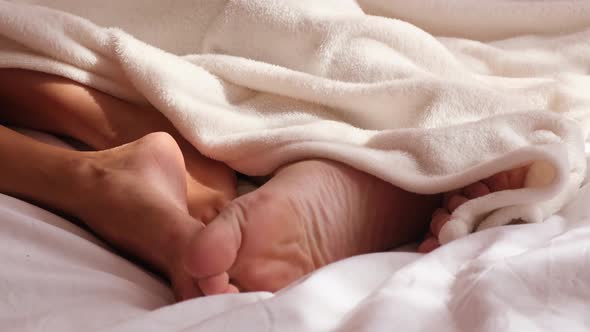 Man Sleeping with Woman Sleeping in Bed Legs View