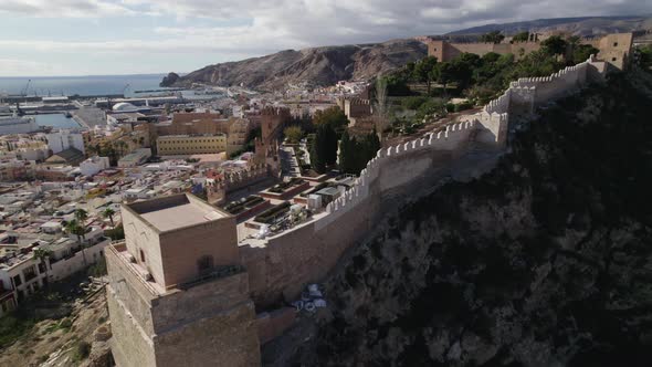 Aerial ascending revealing Scenic Alcabaza of Almería, by mediterranean Sea. Spain