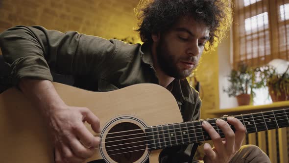 Young Talented Man Playing Guitar Performing Music at Home Improvising Melody By Himself