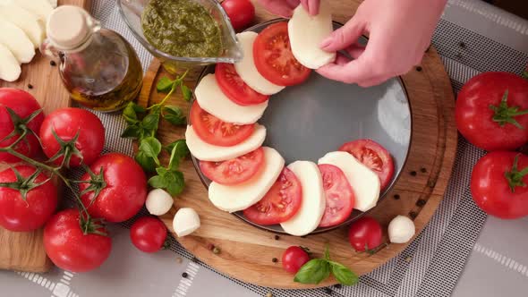 Making Caprese Salad  Putting Sliced Tomatoes and Mozzarella on a Plate