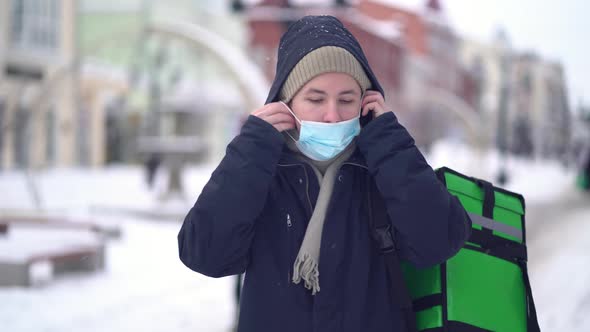 Courier Is Delivering Food with Backpack at Winter