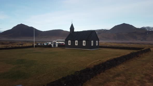 Tiny wooden church in a scenic natural area with a lava field.