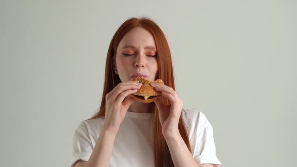 Closeup Portrait of Cheerful Young Woman with Appetite to Eat Tasty Burger and Looking at Camera