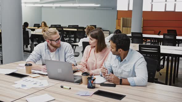 Diverse Employees Working at Laptop Discussing Ideas and Goals Concerning to a New Design Project