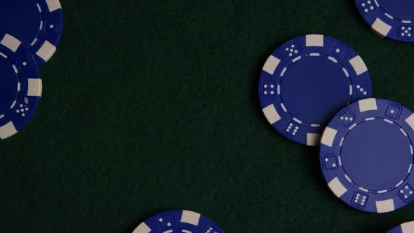 Rotating shot of poker cards and poker chips on a green felt surface - POKER 024