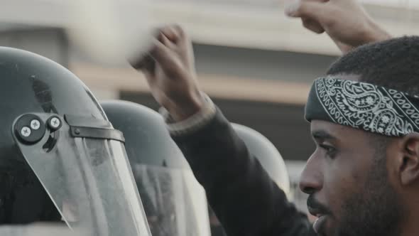 Black Protester Chanting before Riot Policemen