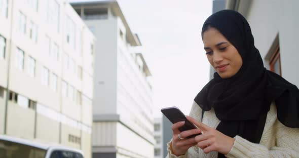 Woman in hijab texting on the street 4k