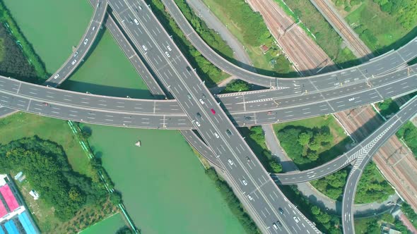 Aerial Top Down View of a Highway Overpass Multilevel Junction with Fast Moving Cars Surrounded By