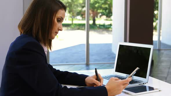 Businesswoman working on laptop at desk 4k