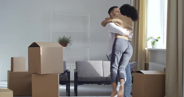Multiethnic Multiracial Couple Hugging Surrounded By Cardboard Boxes Man Husband Caucasian Guy