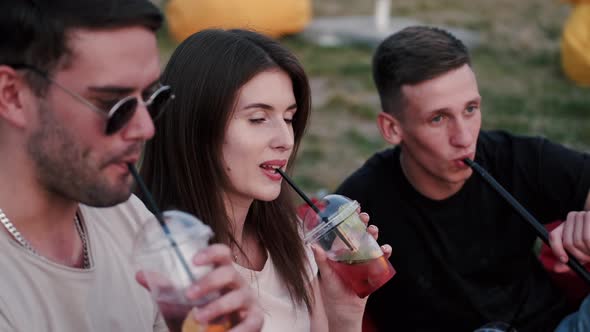 Two European Boys Are Smoking and a Girl Is Drinking a Cockta