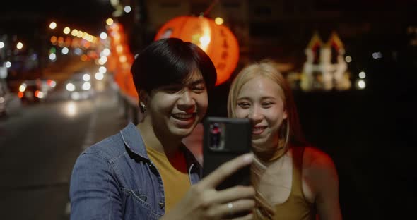 Young Asian couple travel make a video live streaming on social network by smartphone.