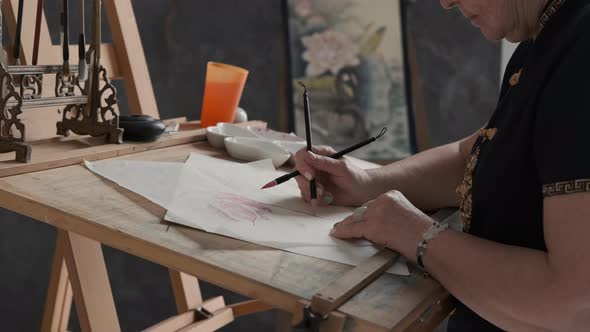 Elderly Woman Painting in Chinese Style Indoors