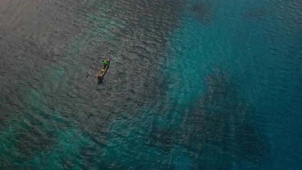 Birds Eye Aerial View on People in Boat with Outrigger in Blue Tropical Sea Water