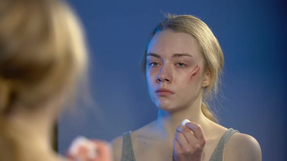 Crying Young Woman Disinfecting Face Wound Looking in Mirror, Problem Despair