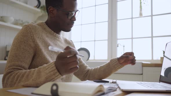 Young African American Man Works Online Looking at Flat Key