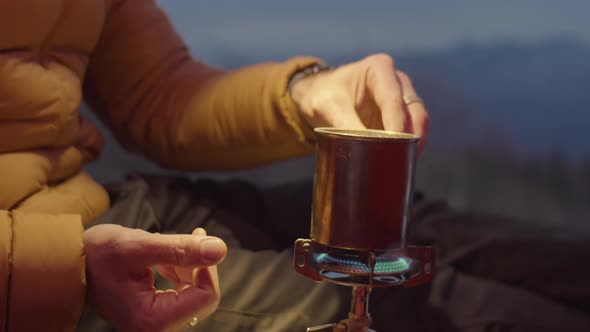 Man Using Portable Gas Stove in Camping Tent